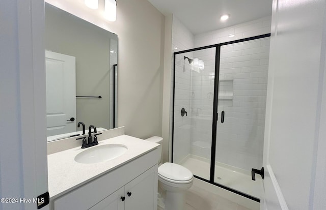 bathroom with vanity, a shower with shower door, and toilet