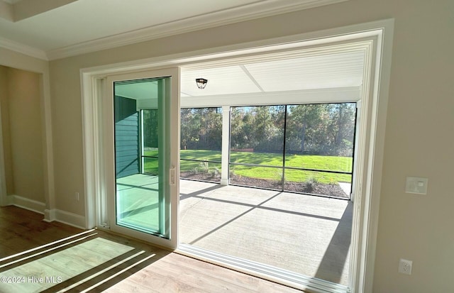 doorway to outside featuring a wealth of natural light, wood-type flooring, and ornamental molding