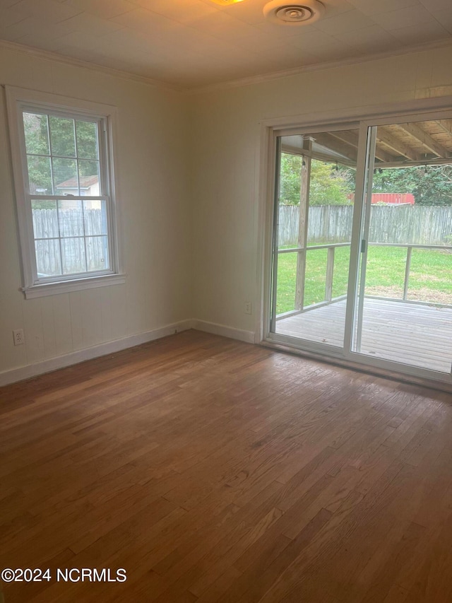 unfurnished room with hardwood / wood-style flooring and ornamental molding