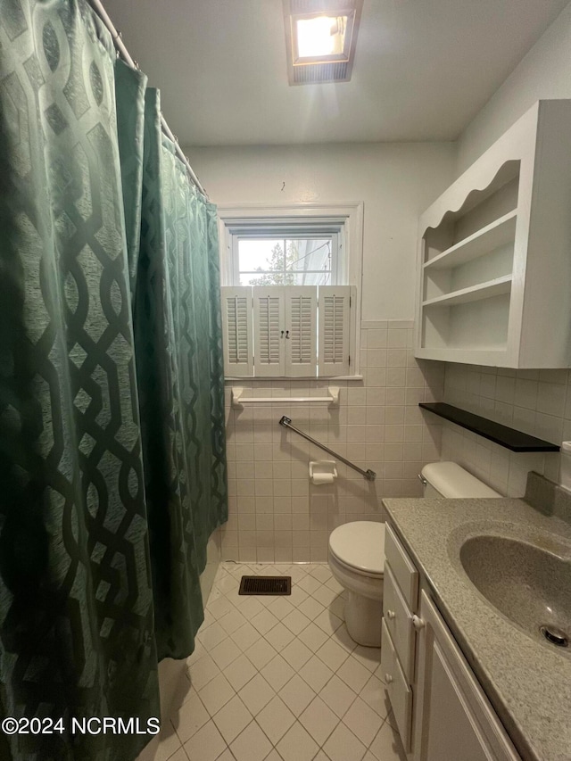 bathroom with tile walls, tile patterned flooring, vanity, and toilet