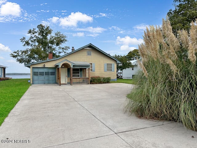 view of front of home with a water view and a garage