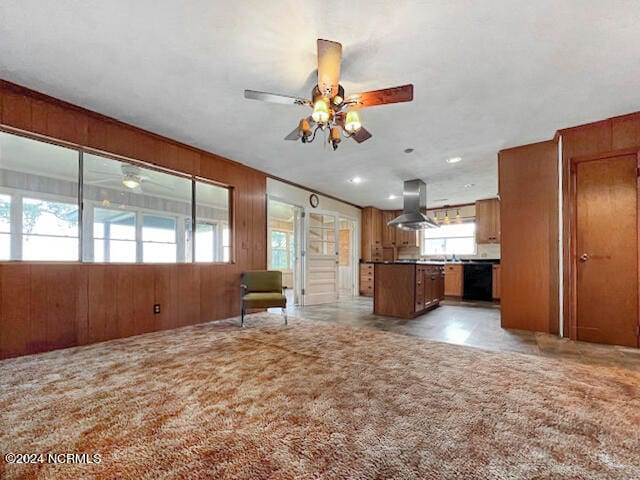 kitchen with light carpet, wood walls, island exhaust hood, and ceiling fan