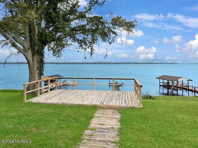 dock area featuring a lawn and a water view