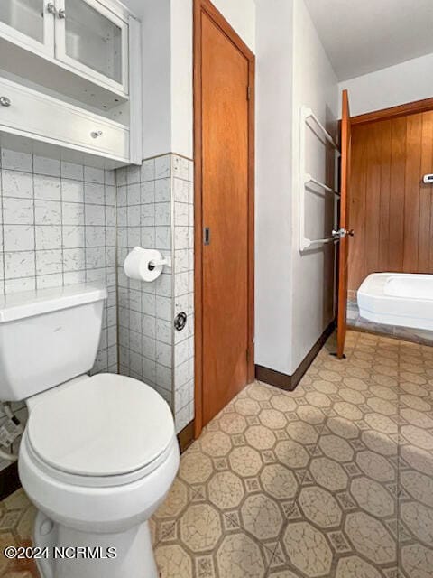 bathroom with toilet and tasteful backsplash