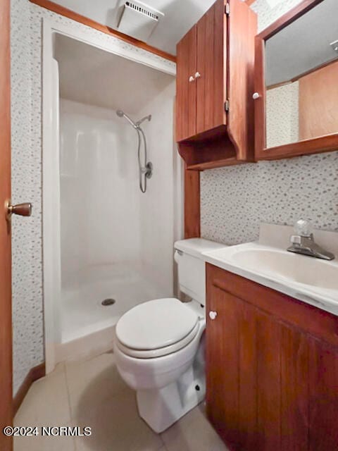 bathroom featuring a shower, vanity, and toilet