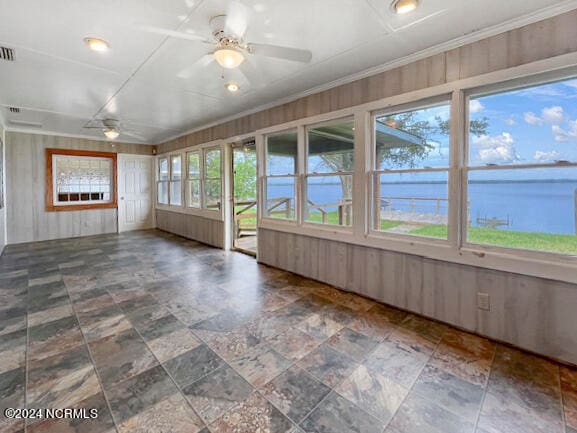 unfurnished sunroom featuring a water view, ceiling fan, and plenty of natural light