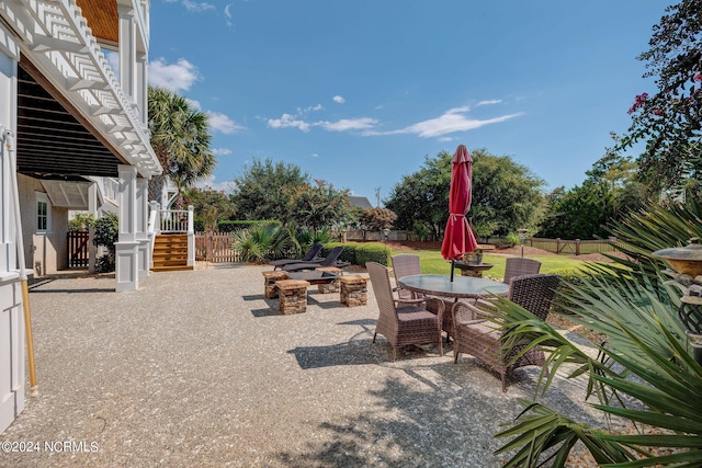 view of patio with stairway, a fenced backyard, and outdoor dining area