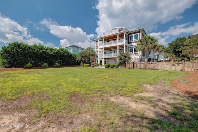 view of yard with fence and a balcony