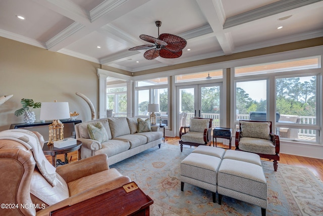 living room featuring light wood-type flooring, beamed ceiling, ornamental molding, and ceiling fan