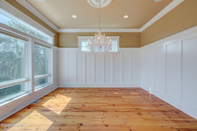 unfurnished dining area featuring light hardwood / wood-style flooring, plenty of natural light, and ornamental molding