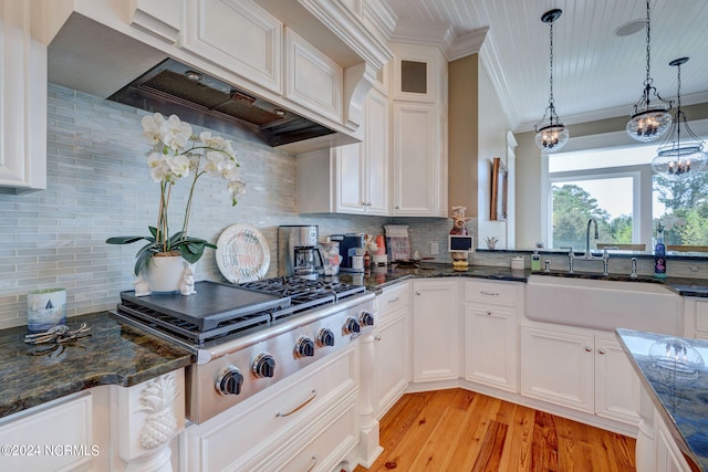 kitchen featuring decorative backsplash, white cabinetry, pendant lighting, light wood-type flooring, and stainless steel gas stovetop