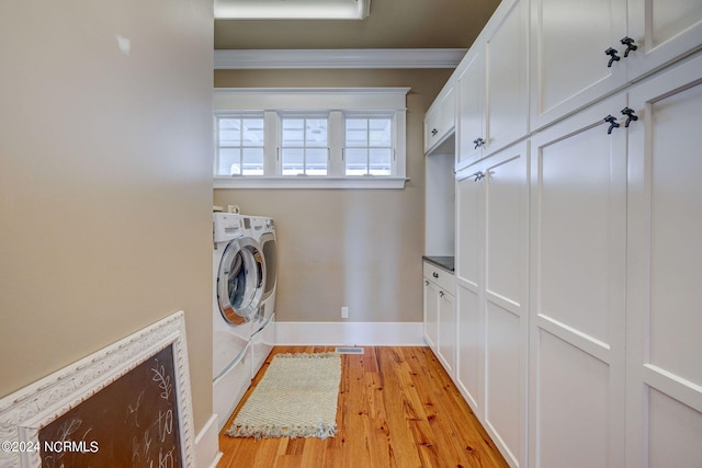 laundry room with cabinets, light hardwood / wood-style flooring, ornamental molding, and washing machine and dryer