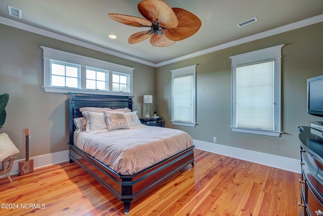 bedroom with ornamental molding, ceiling fan, and light hardwood / wood-style flooring