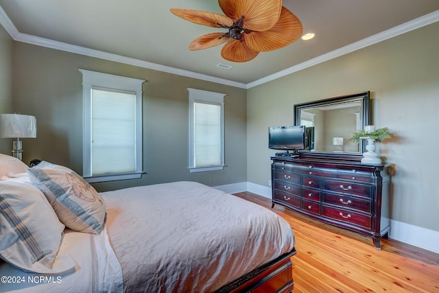 bedroom with visible vents, ornamental molding, light wood-type flooring, baseboards, and ceiling fan