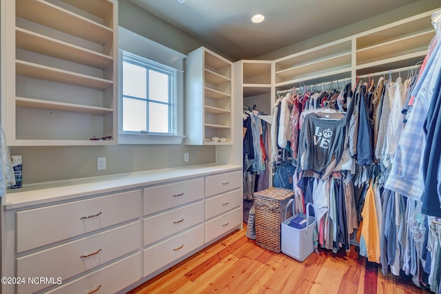 walk in closet with light wood-style floors