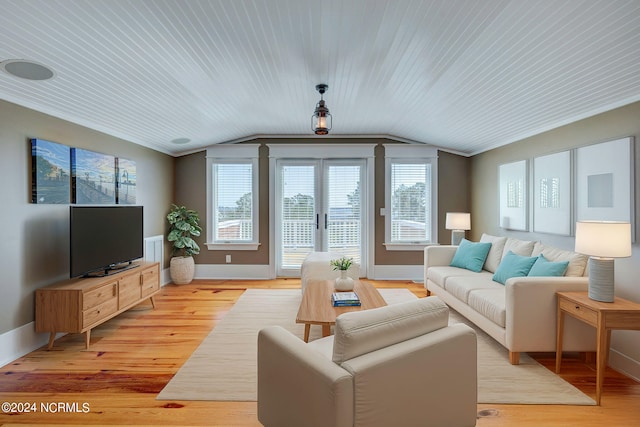 living room with ornamental molding, light wood-type flooring, and vaulted ceiling