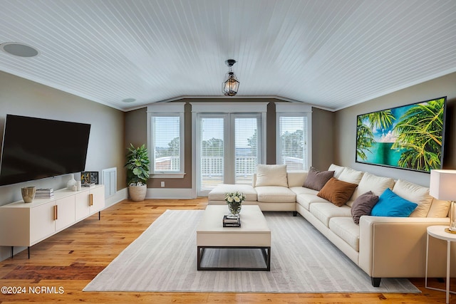 living room featuring crown molding, lofted ceiling, and light hardwood / wood-style flooring