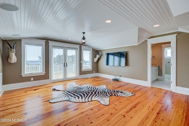 exercise room with light wood-type flooring, lofted ceiling, french doors, and plenty of natural light