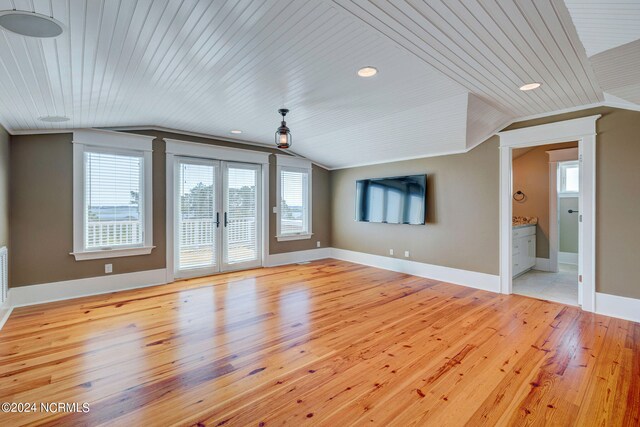 unfurnished living room with light hardwood / wood-style flooring, a wealth of natural light, and lofted ceiling