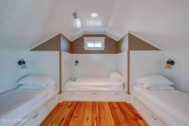 bedroom with light wood-type flooring, vaulted ceiling, wooden ceiling, and wooden walls