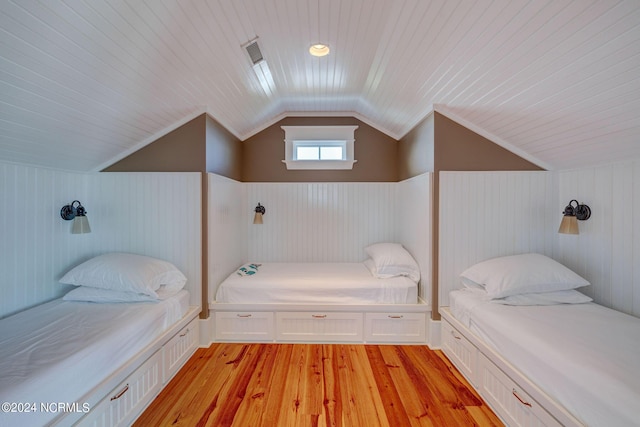 bedroom featuring wood ceiling, lofted ceiling, a wainscoted wall, and light wood-type flooring