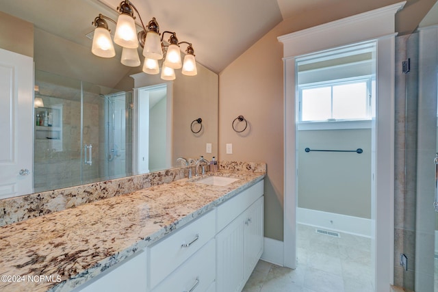 bathroom featuring vanity, lofted ceiling, a shower with shower door, and tile patterned floors