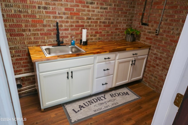 interior space with butcher block countertops, sink, dark hardwood / wood-style floors, and white cabinets