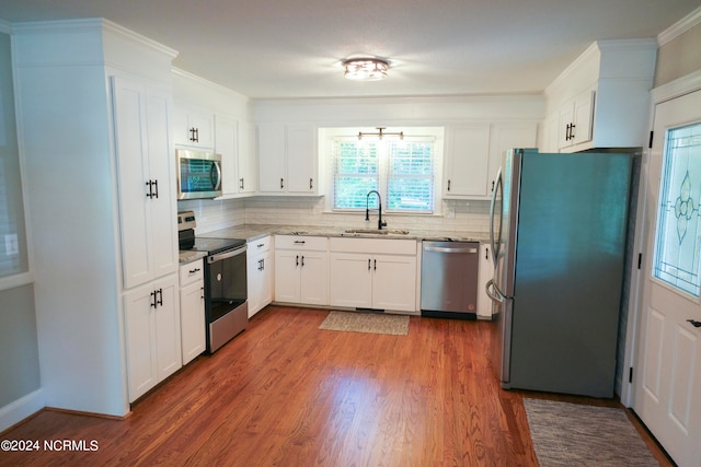 kitchen featuring white cabinetry, dark wood-type flooring, tasteful backsplash, stainless steel appliances, and sink