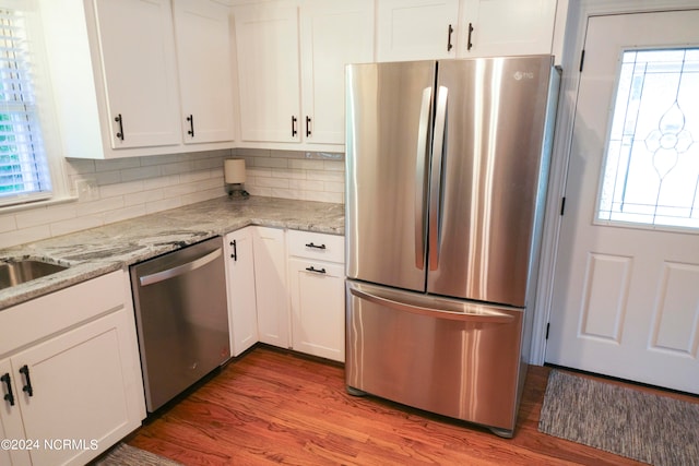 kitchen with white cabinets, stainless steel appliances, and a wealth of natural light