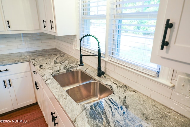 kitchen featuring white cabinets, backsplash, and sink