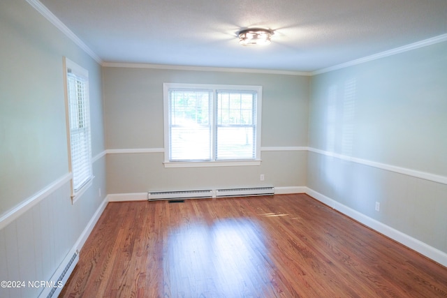 spare room with wood-type flooring, baseboard heating, and ornamental molding