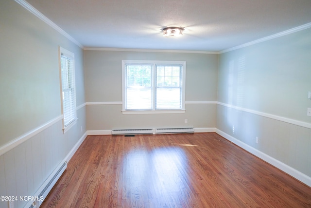 empty room featuring ornamental molding, a baseboard heating unit, and wood-type flooring