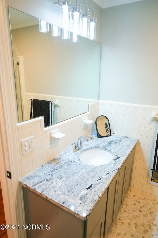 bathroom featuring ornamental molding, tile walls, and vanity