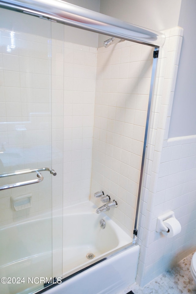 bathroom with enclosed tub / shower combo and toilet