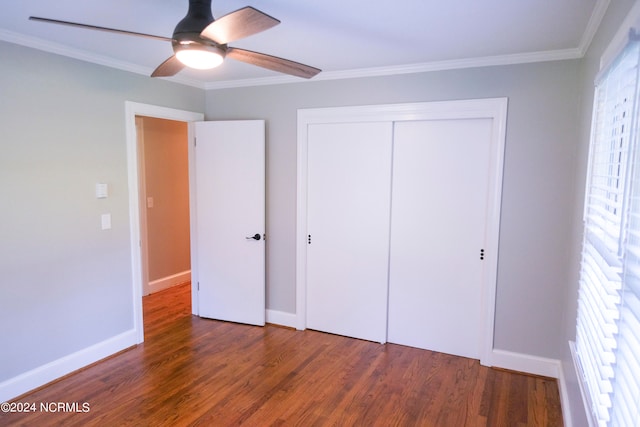 unfurnished bedroom with crown molding, ceiling fan, dark wood-type flooring, and a closet