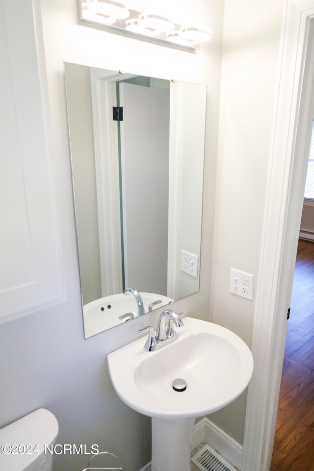 bathroom featuring hardwood / wood-style floors, toilet, and sink