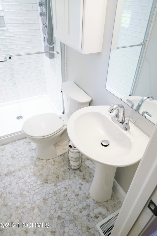 bathroom featuring a tile shower and toilet