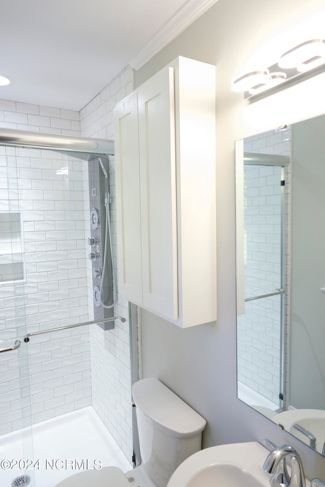 bathroom featuring toilet, sink, and an enclosed shower