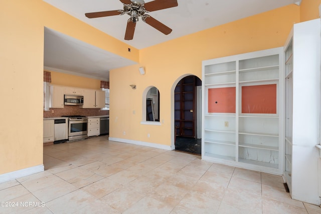 interior space with ornamental molding, light tile patterned flooring, and ceiling fan