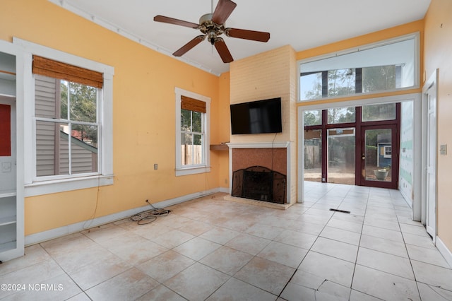 unfurnished living room featuring a healthy amount of sunlight, light tile patterned floors, and ceiling fan