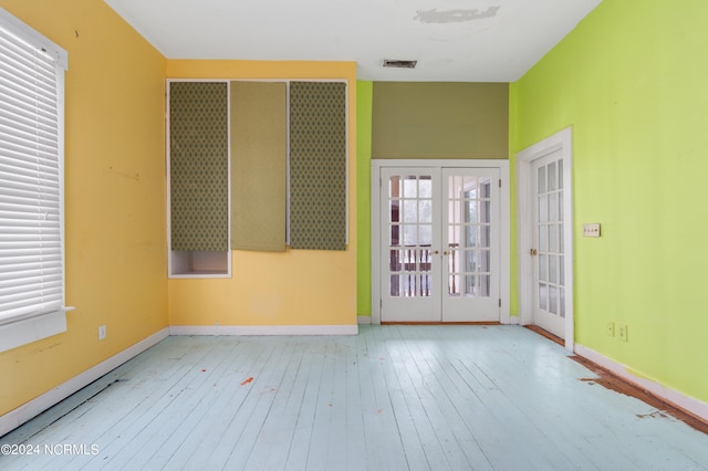 spare room with french doors and light hardwood / wood-style flooring