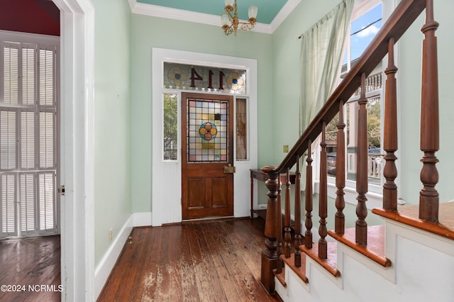 entryway featuring ornamental molding, an inviting chandelier, and dark wood-type flooring