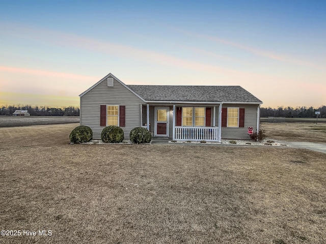 ranch-style home with a lawn and a porch