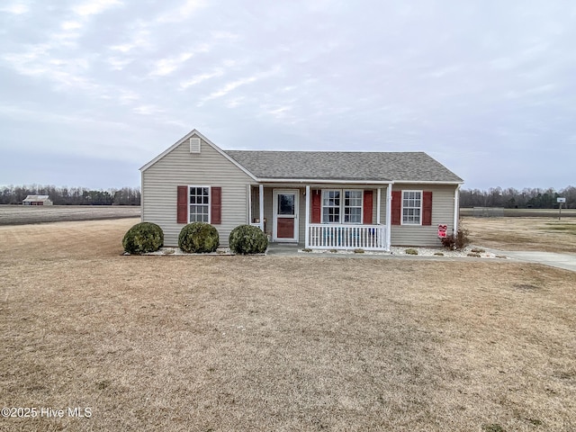 ranch-style house featuring covered porch and a front lawn