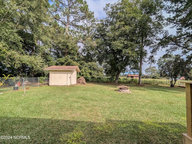 view of yard featuring an outdoor fire pit and a shed