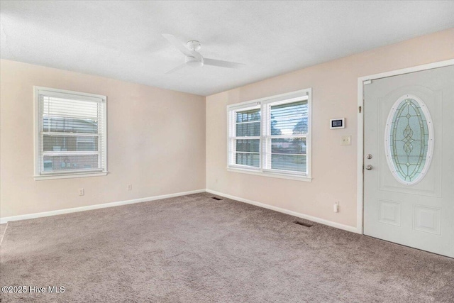 entrance foyer with ceiling fan, carpet floors, and a textured ceiling