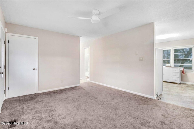 carpeted spare room featuring ceiling fan