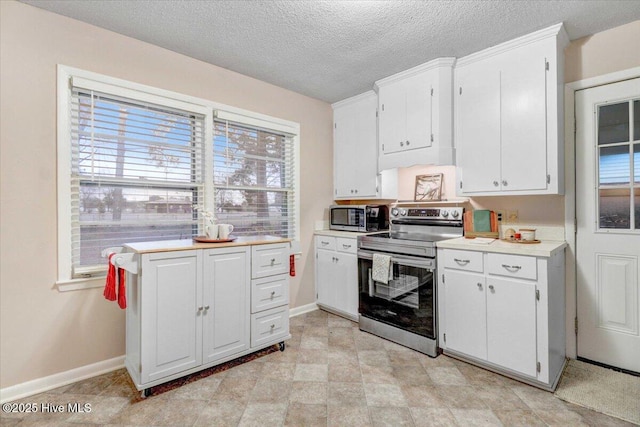 kitchen featuring white cabinetry, stainless steel appliances, and a textured ceiling