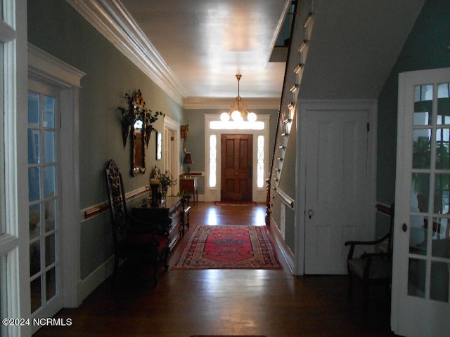 entrance foyer with ornamental molding, dark hardwood / wood-style floors, and an inviting chandelier