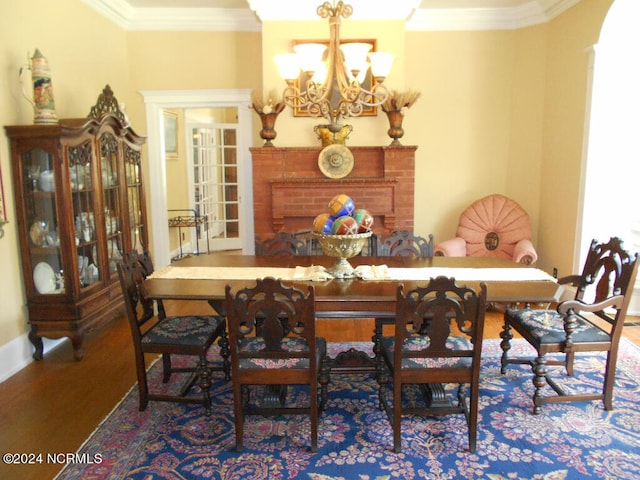 dining space with an inviting chandelier, crown molding, and wood-type flooring